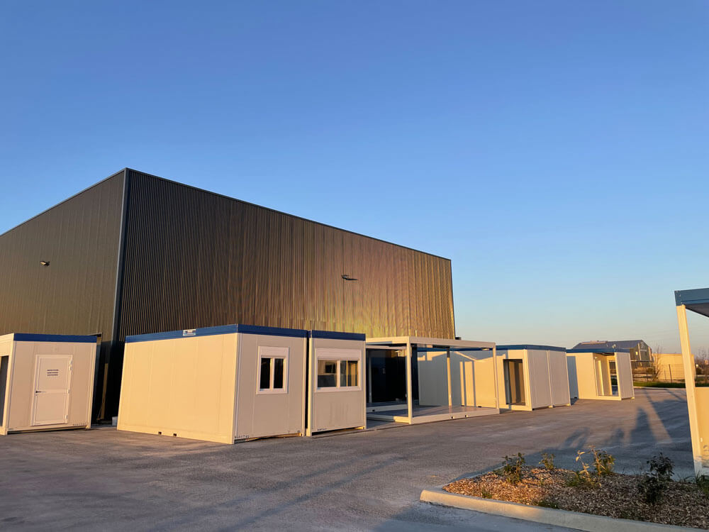 Bâtiments modulaires Petit Location installés devant un entrepôt industriel à Chartres en journée.